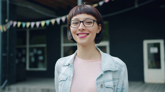 慢动作肖像的年轻褐发女人看着相机和微笑的户外视频素材