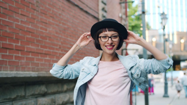 一个漂亮的黑发女人的肖像走在户外转向镜头指向微笑视频素材