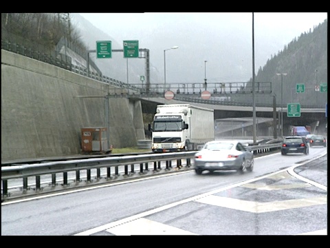 在一个雨夜，车辆在瑞士的圣哥达公路隧道进进出出。视频素材