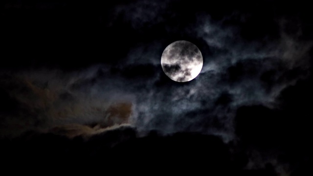 神秘的夜空中布满了戏剧性的满月云，月光皎洁。视频素材