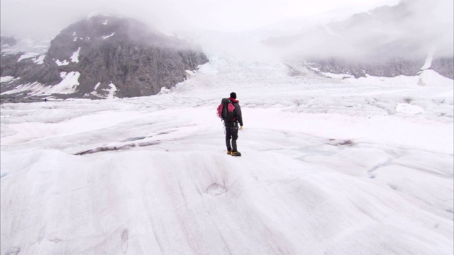 一位徒步旅行者站在阿拉斯加朱诺冰原的雪峰上。视频素材