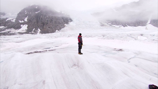 一位徒步旅行者站在阿拉斯加朱诺冰原的雪峰上。视频素材