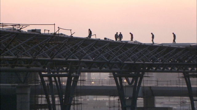 建筑工人在上海虹桥国际机场正在建设的立交桥上走动。视频素材