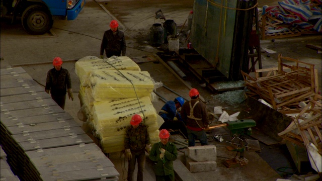 在虹桥综合交通枢纽的工地上，建筑工人正在用手推车搬运材料。视频素材