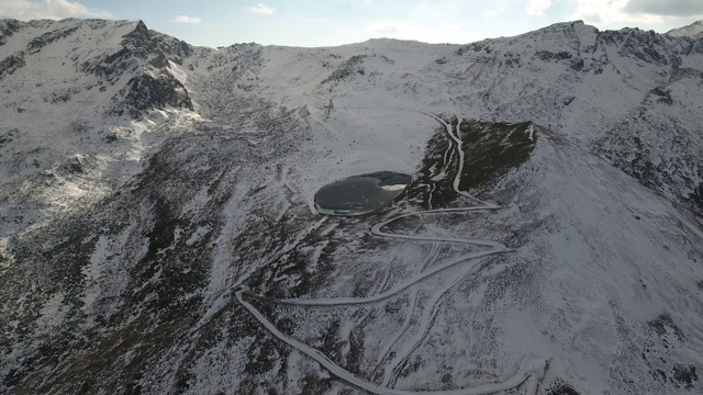 鸟瞰图冰冻的湖和火山上的雪。视频素材