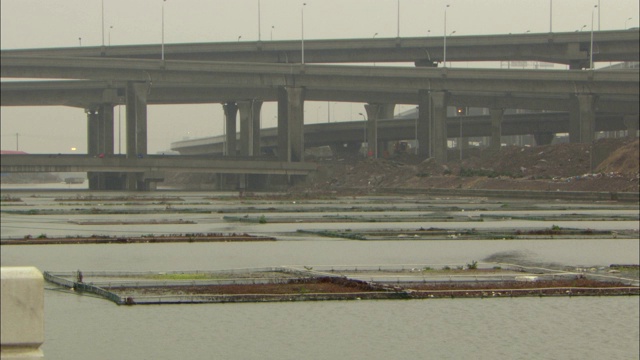 高速公路的车道在垃圾填埋场和河流上方纠结。视频素材