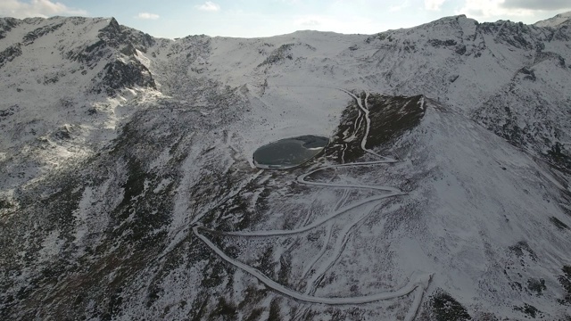 鸟瞰图冰冻的湖和火山上的雪。视频素材