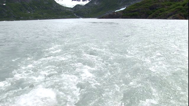 一艘船驶过一座小冰山。视频素材