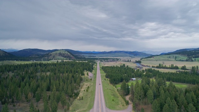 早春，在蒙大拿格里诺附近的MT 200高速公路上，鸟瞰落基山、刘易斯和克拉克国家森林和鲑鱼湖州立公园。无人机视频与向后相机运动。视频素材