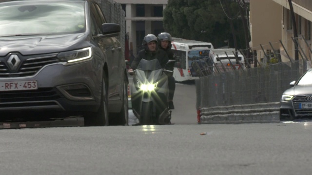 汽车和摩托车在摩纳哥公路上慢动作行驶，路边有防撞护栏视频下载