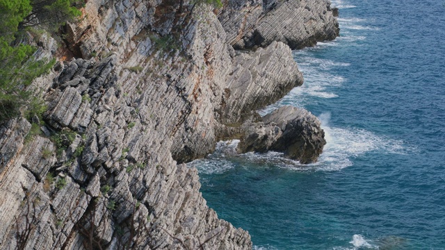 岩石和蓝色波浪海面，俯视图。自然背景视频素材