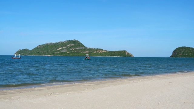 海浪拍打着棕色的沙滩，蓝天白云视频素材