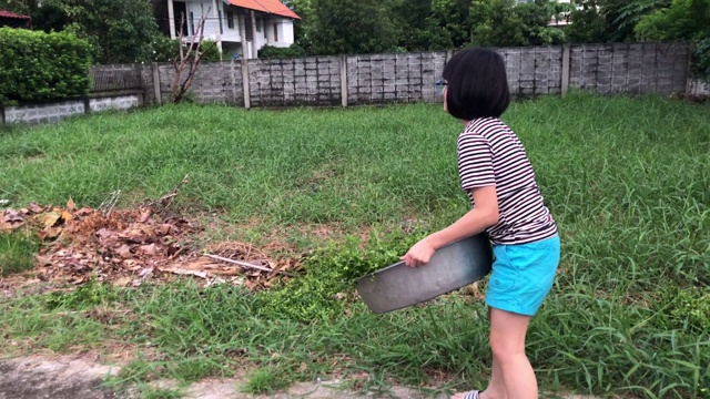 全家在一起做家务，女孩在清扫树叶视频素材