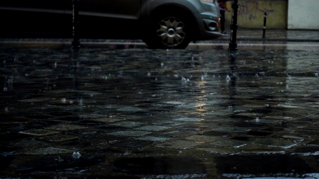 雨中的欧洲城市抽象镜头。专注于落下的雨滴。汽车和行人的街道散焦了视频素材