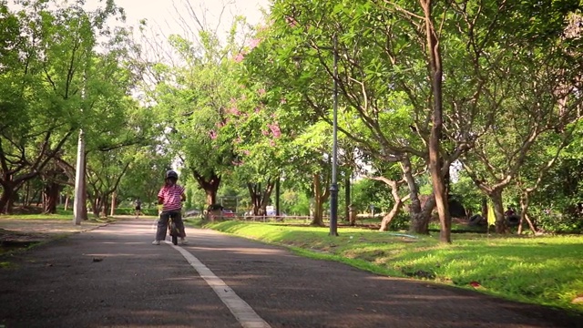 孩子们骑着自行车在柏油路上平衡。视频素材