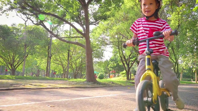 孩子们骑着自行车在柏油路上平衡。视频素材