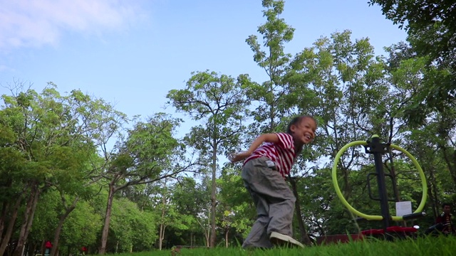 在夏天的蓝天里，孩子们在杂草上奔跑跳跃。跳过小溪。视频素材