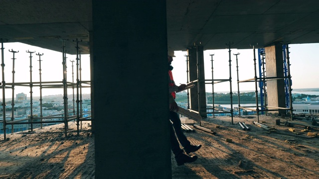 建筑工人正沿着正在施工的建筑走着视频素材