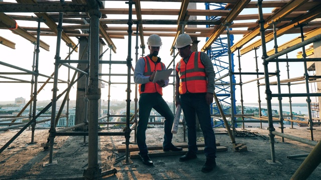 男建筑师在脚手架工地上交谈视频素材