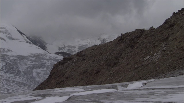 一个孤独的背包客沿着山脊徒步旅行。视频素材