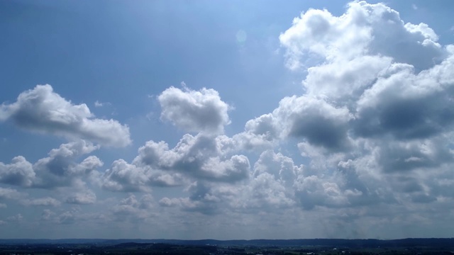 白色蓬松的云与蓝色的天空从左到右缓慢缩小视频素材