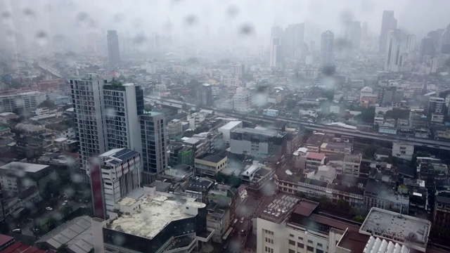 雨滴落在窗户玻璃上，大雨落在曼谷地标的背景上视频素材