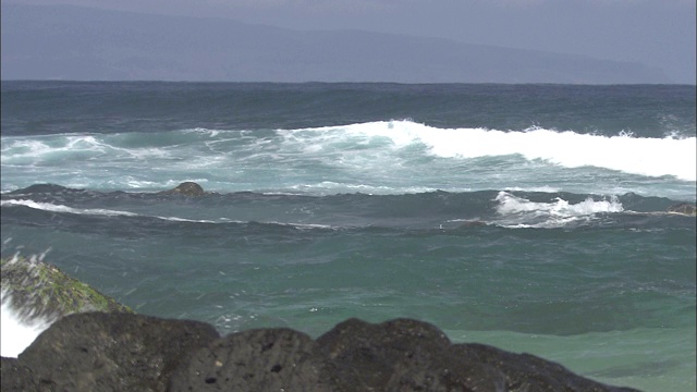 海浪冲击着布满岩石的海岸线。视频素材