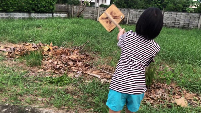 全家在一起做家务，女孩在清扫树叶视频素材