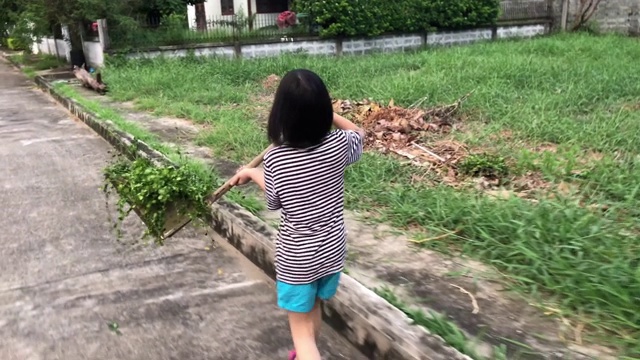 全家在一起做家务，女孩在清扫树叶视频素材