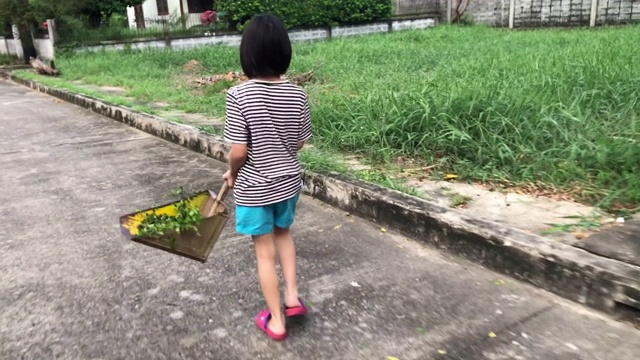 全家在一起做家务，女孩在清扫树叶视频素材