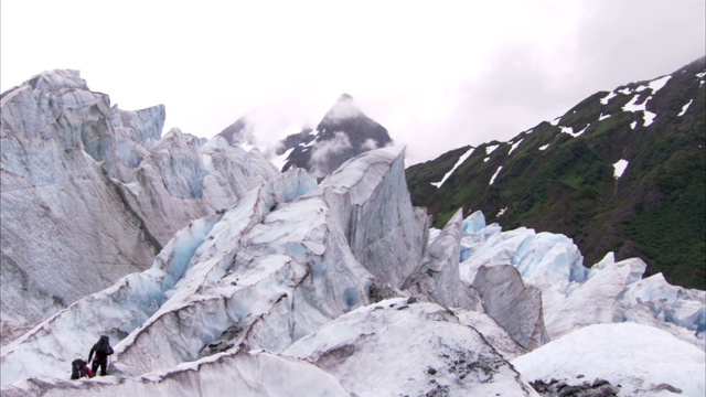 登山者在朱诺冰原崎岖不平的冰川上徒步行走。视频素材