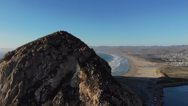 mb157_在海滩上飞得很高，看着Morro岩石的顶端，回去，露出海滩的延伸。视频下载