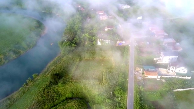 通过雾霾可以看到山谷中沿道路和河流的上部运动视频素材