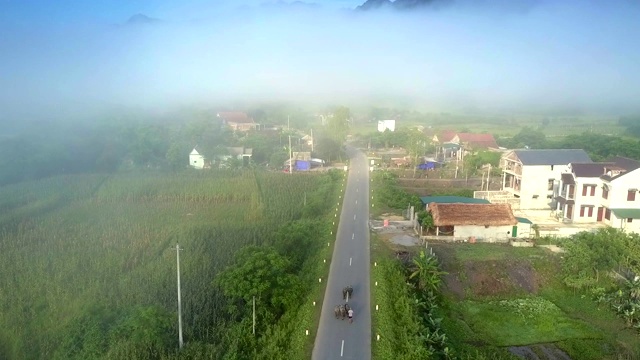 在朦胧的地平线上的道路和村庄房屋之上的运动视频素材