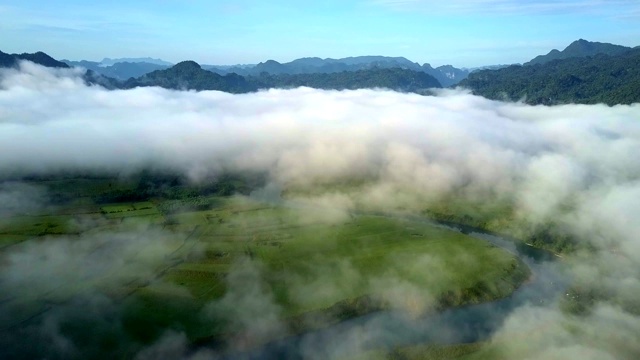 云彩覆盖着山谷，河流和奇异的山丘映衬着天空视频素材