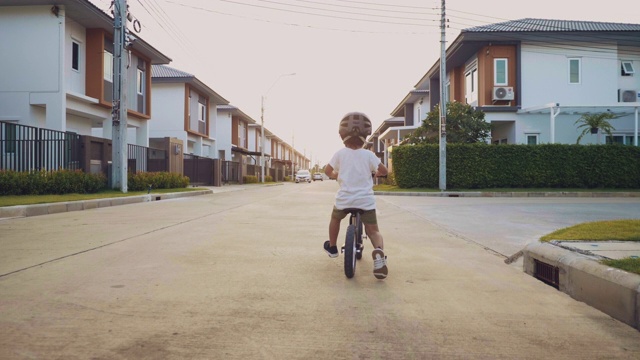 蹒跚学步的孩子骑着平衡自行车。视频素材