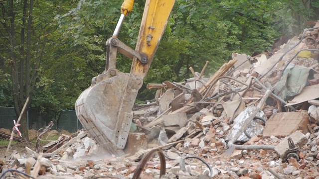 特写斗式挖掘机在拆除工地清理垃圾。拆除旧工业建筑。视频素材