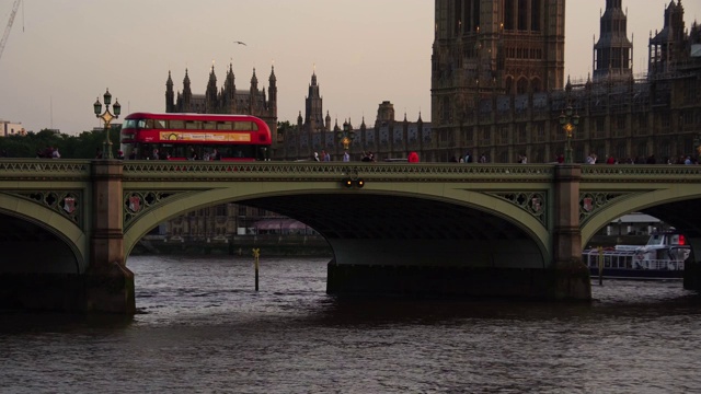 红色双层巴士驶过英国伦敦标志性大桥。视频素材