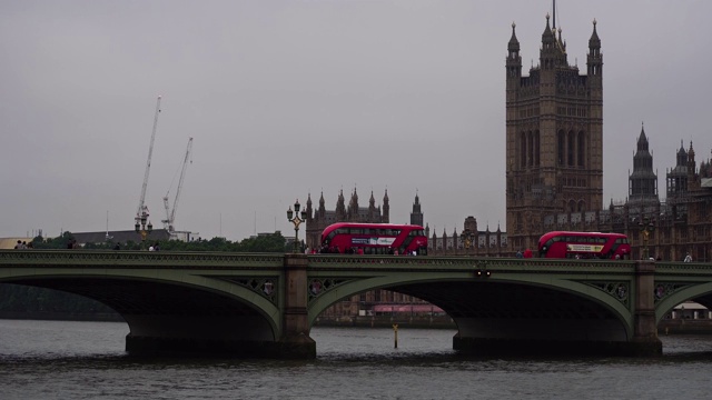 红色双层巴士驶过英国伦敦标志性大桥。视频素材