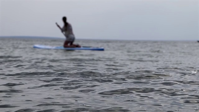 女孩在餐桌上。水上运动,supsurfing。周末在海上活跃，女人休闲站视频素材