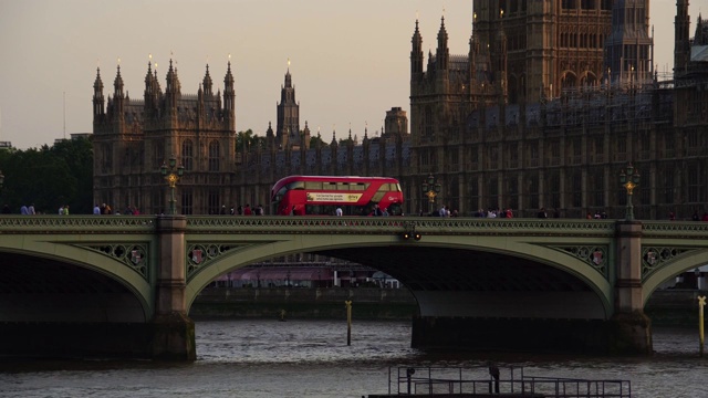 红色双层巴士驶过英国伦敦标志性大桥。视频素材