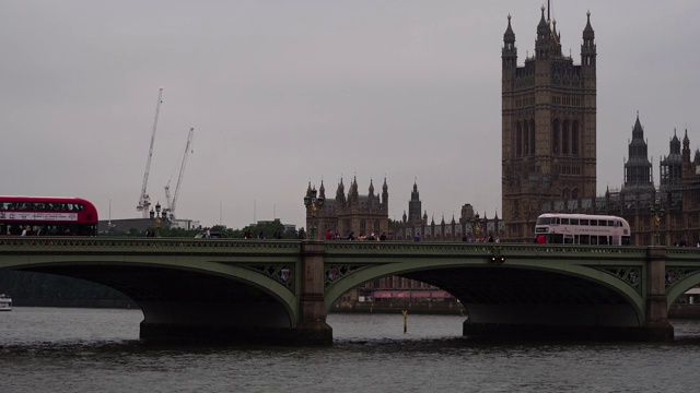 红色双层巴士驶过英国伦敦标志性大桥。视频素材