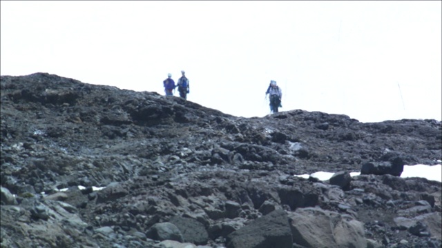 登山者徒步穿越巴塔哥尼亚一个多雪多石的斜坡，视频素材