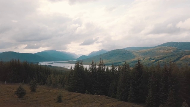 飞过苏格兰森林。湖和山的背景。空中无人机视频视频素材