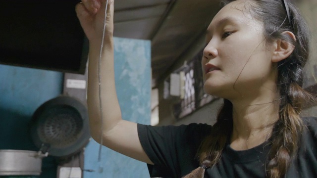 亚洲年轻女孩准备混合意大利食物烹饪黑色意大利面与鱼，拍摄膳食与移动相机。视频素材