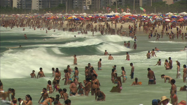 海浪冲击着拥挤的海滩。视频素材