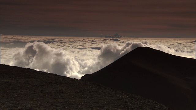 在夏威夷的莫纳克亚山，低洼的云漂浮在山顶后面。视频素材