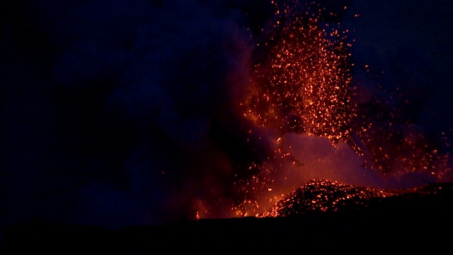 莫纳克亚火山上的火山口爆发出耀眼的熔岩，照亮了夜空。视频素材