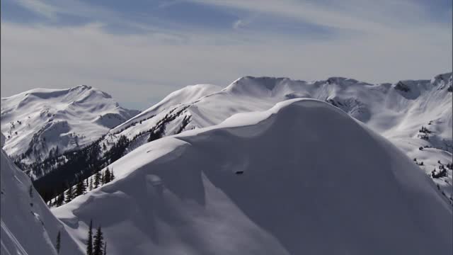 在山脊上爆炸后，雪迅速地从斜坡上流下。视频素材