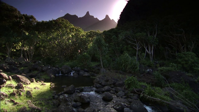 金色的阳光透过山峰，在火奴鲁鲁钻石山的一条岩石河上闪闪发光。视频素材